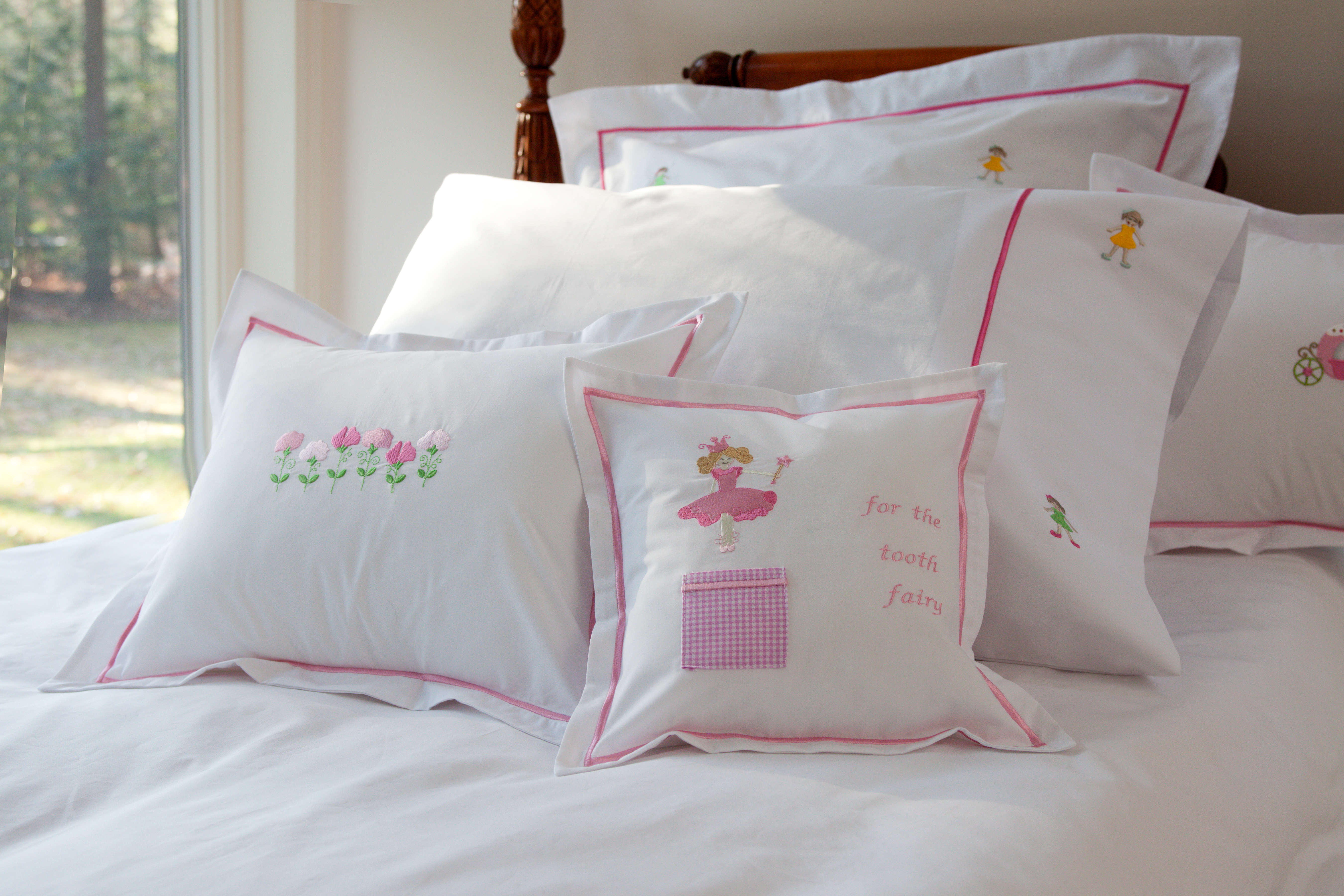 embroidered pillows on a child's bed