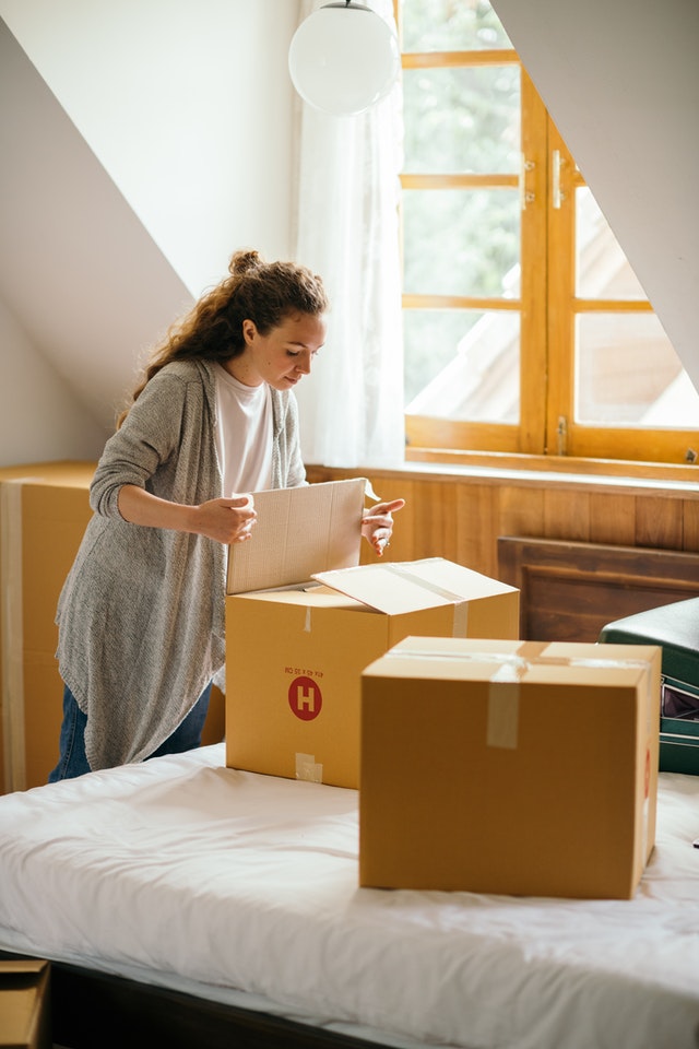 A woman packing boxes in her bedroom