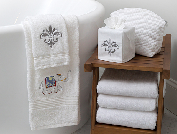 A wooden table or stool with towels stacked on it in a bathroom
