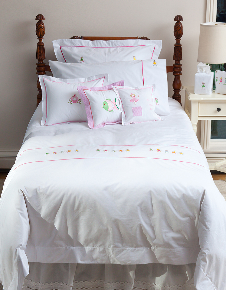 a little girl's bedroom with embroidered linens