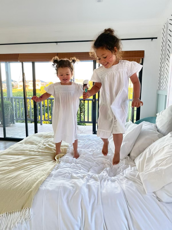Little girls jumping on the bed before packing for their move.